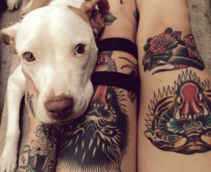 Dog sitting next to tattoo owner